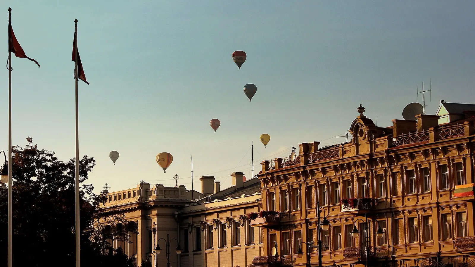 Hot-air balloons drifting over the red rooftops and church spires of Vilnius Old Town